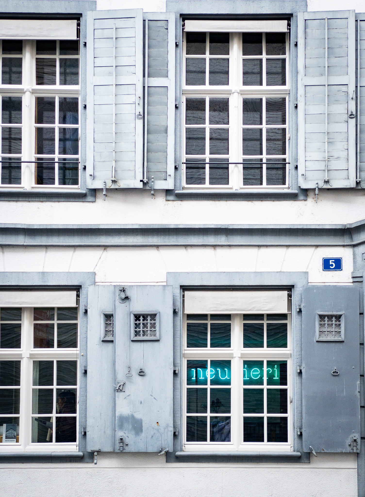 Fassade eines Hauses, Fenster, Neonschriftzug 